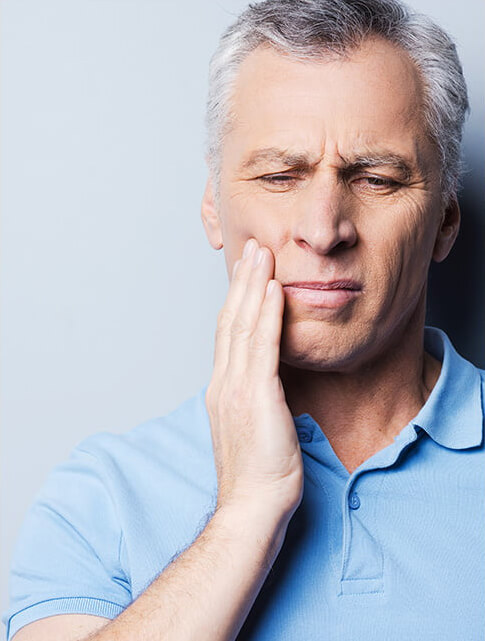 man holding his jaw in pain