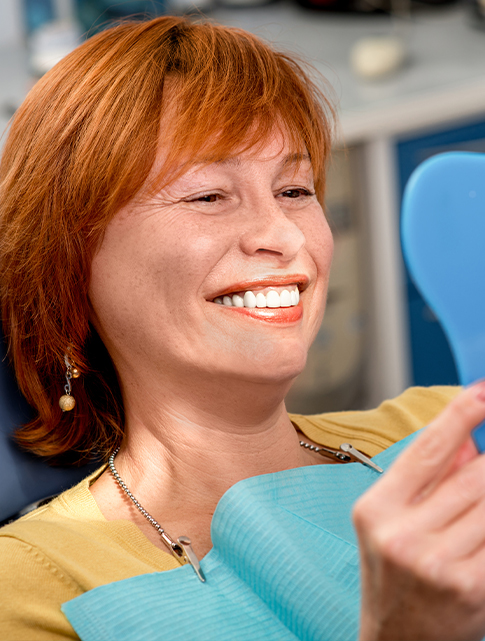 woman checking out smile in mirror