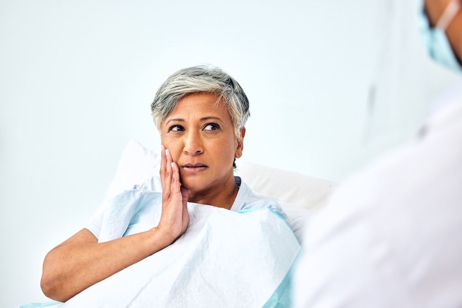 senior woman in dental chair asking how oral health and brain health are connected with gum disease linked to dementia